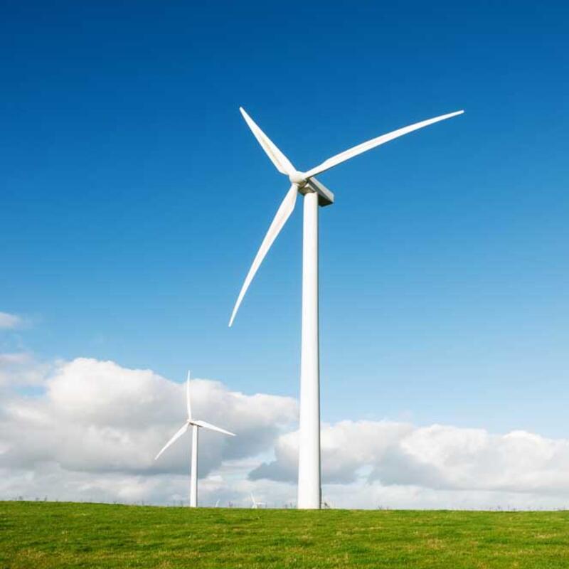 Windmolen op groen veld met blauwe lucht en wolken