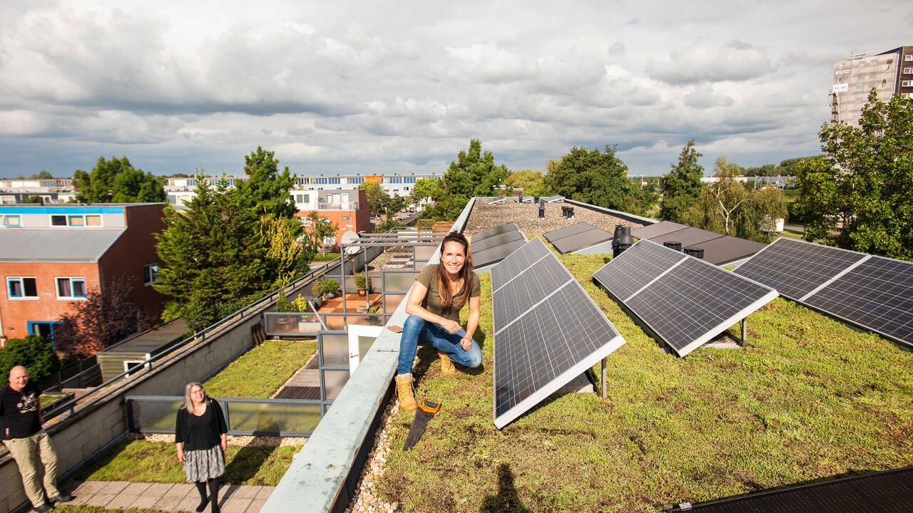Vrouw op groen dak met zonnenpanelen